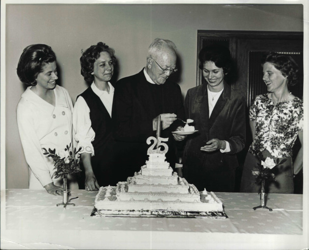 Monsignor William Barry with alumni group at the birthday cake cutting ceremony