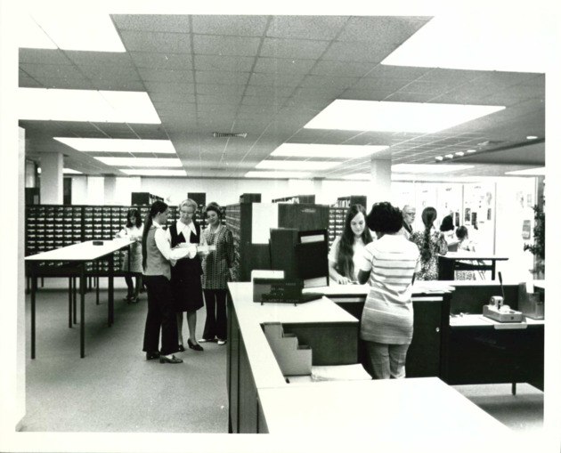 Sister Ann Bernard Goeddeke O.P. with student assistants at the circulation desk of the Monsignor William Barry Memorial Library