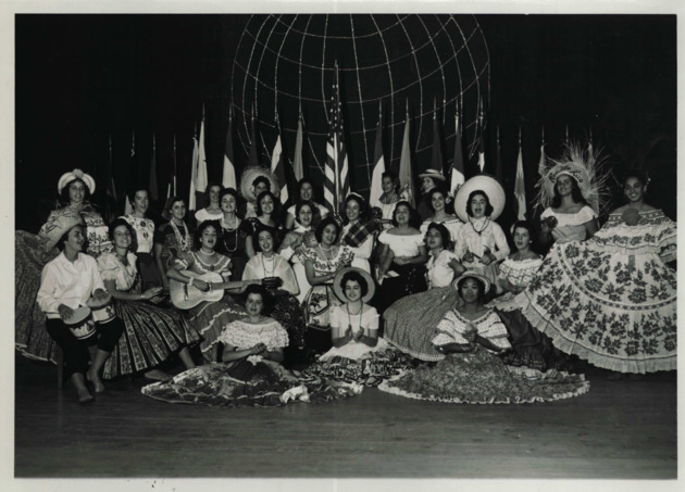 Pan American Day performers pose in front of international flags