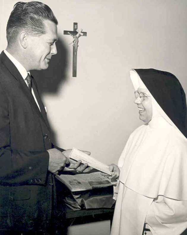 Sister Dorothy Browne, O.P. receives a check from Gulf Oil representative Mr. Hicks