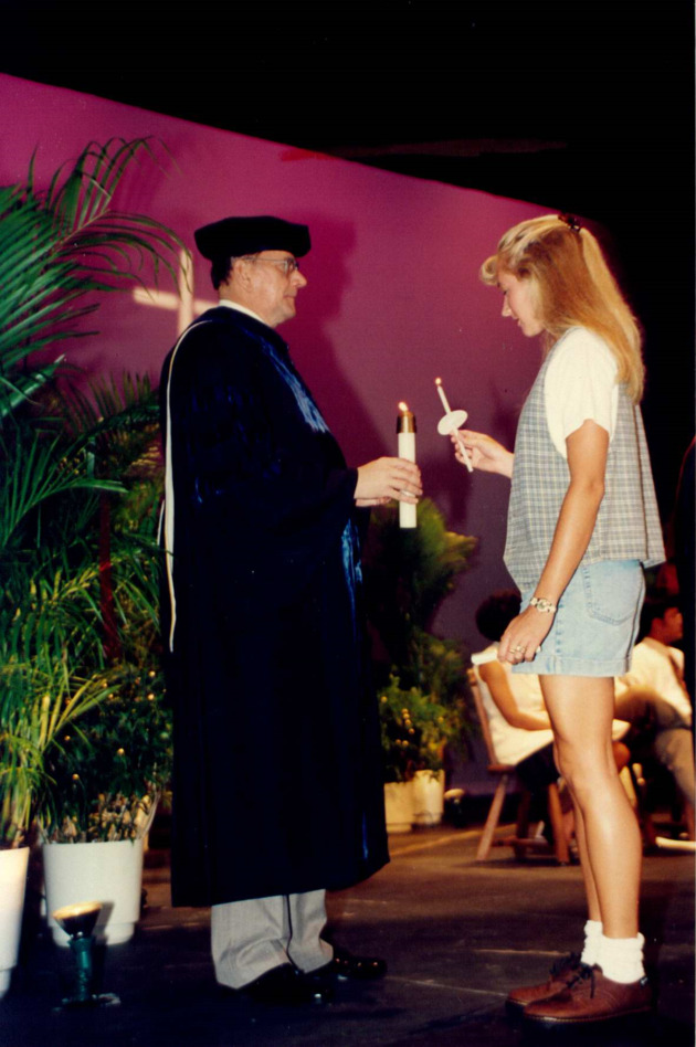 Dr. George Wanko lights a candle with a student during the Mass of the Holy Spirit