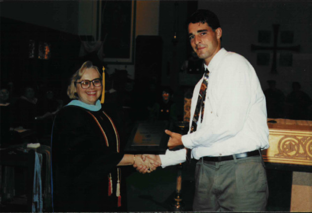 Dr. Eileen McDonough shakes hands with a student at the Honors Convocation