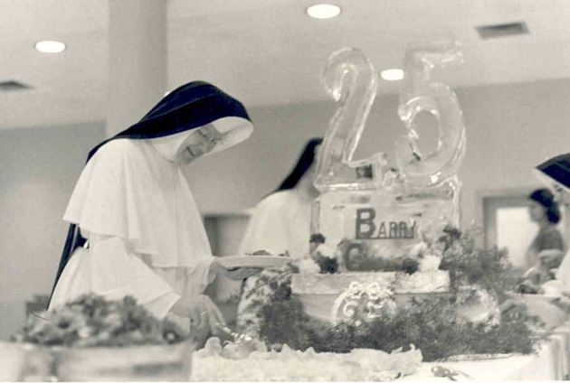 Mother Genevieve Weber, O.P., slicing cake at the Founders Day Silver Jubilee celebration
