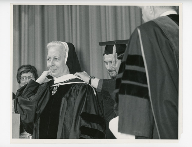 Dr. Daniel Henry affixes the chain of office on Sister Trinita Flood, O.P.
