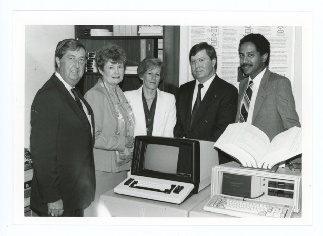 Sister Jeanne O'Laughlin and others surrounding the new Harris 60 super-minicomputer in the School of Computer Science