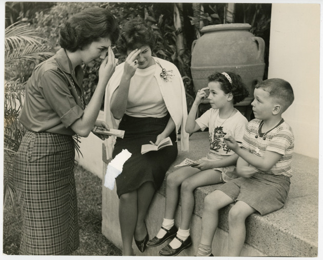 Janice Rocchio and Ariela Carbonell giving catechism instruction to two children